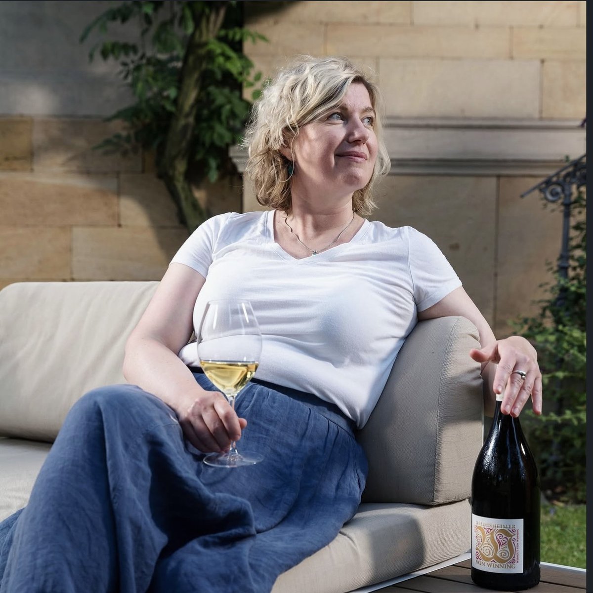 Frau mit Weinglas und Magnumflasche auf dem Sofa