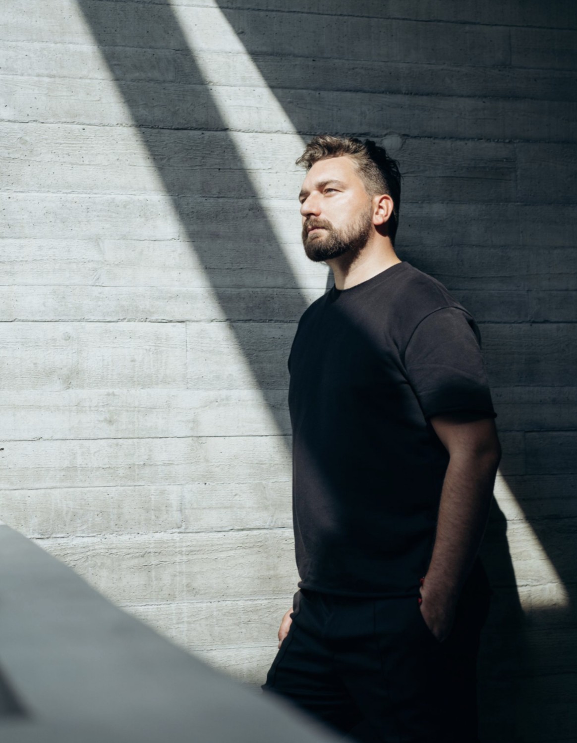 Marcel Heinen, Founder, Chefredakteur und Creative Director, Porträt an Sichtbetonwand
