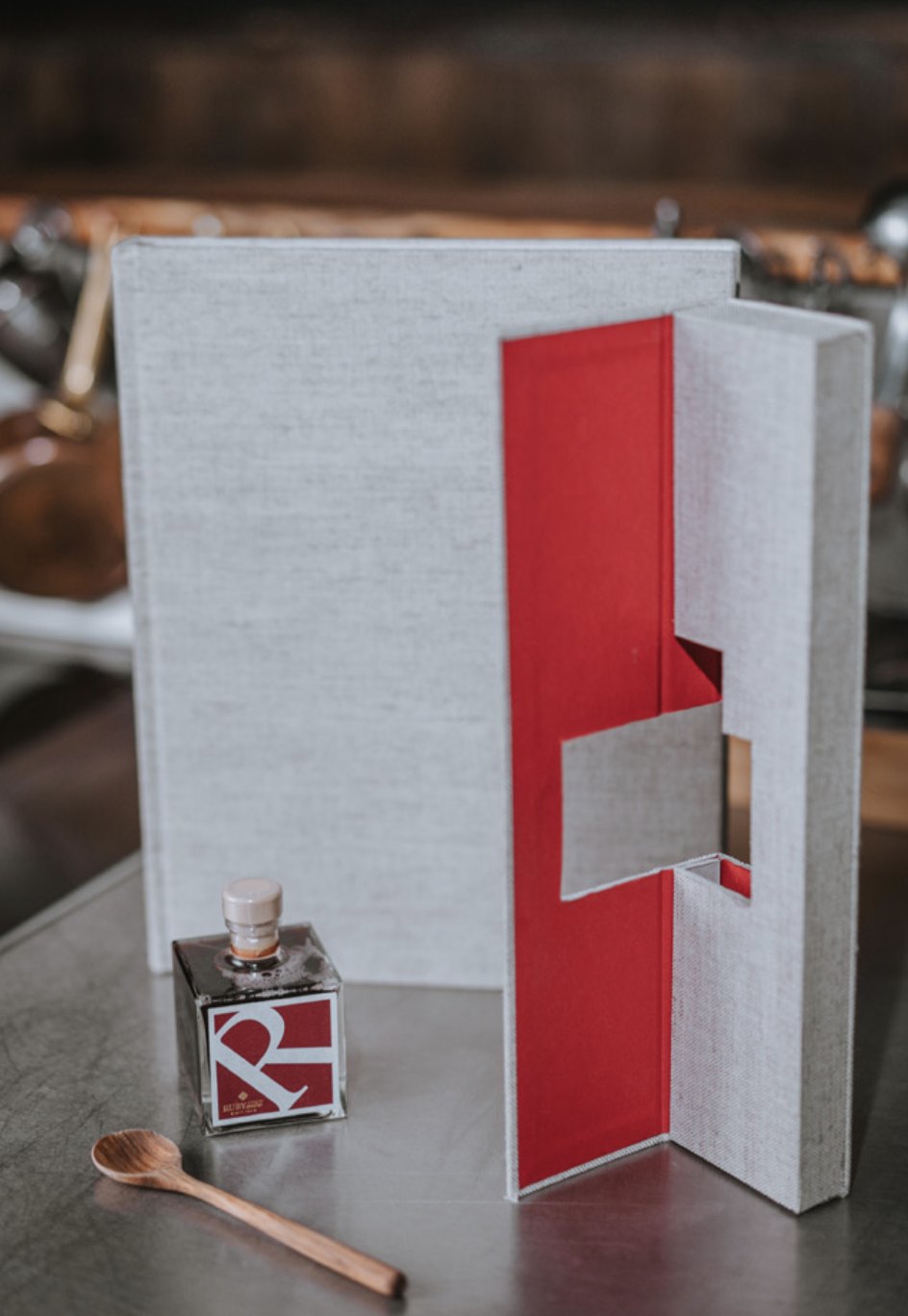 Aufgeklapptes MANI-Cover mit roter Innenseite und RUBYcube-Flasche