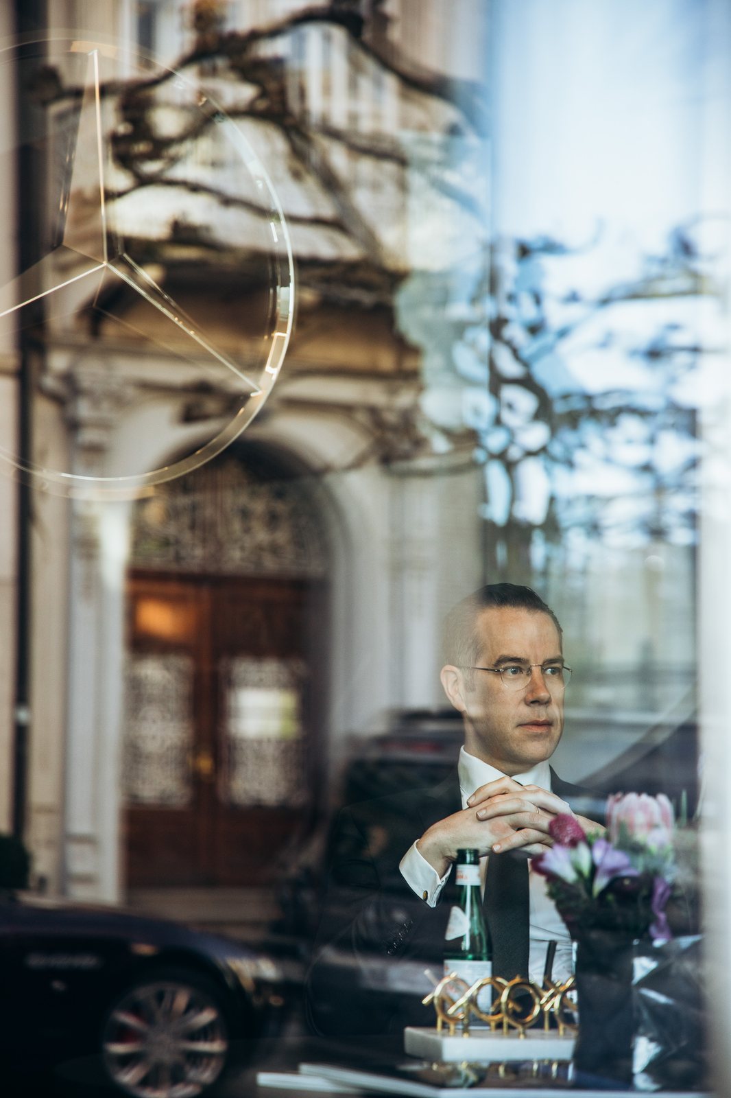 Parfümeur mit Flakon hinter dem Schaufenster