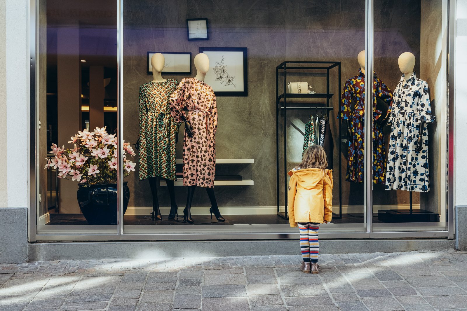 Boutique-Fassade mit Blumen und Sommerkleidern