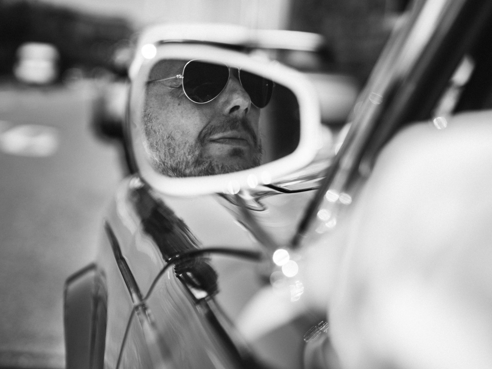 Mann mit Sonnenbrille im Cabrio, Schwarzweiß