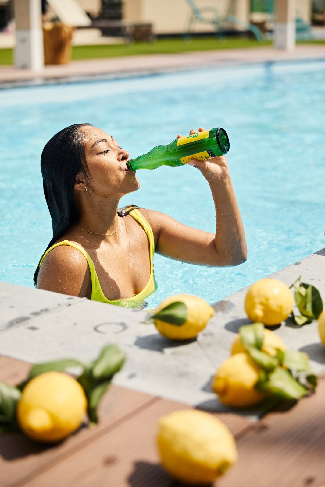 Frau trinkt Welde Naturradler am Pool