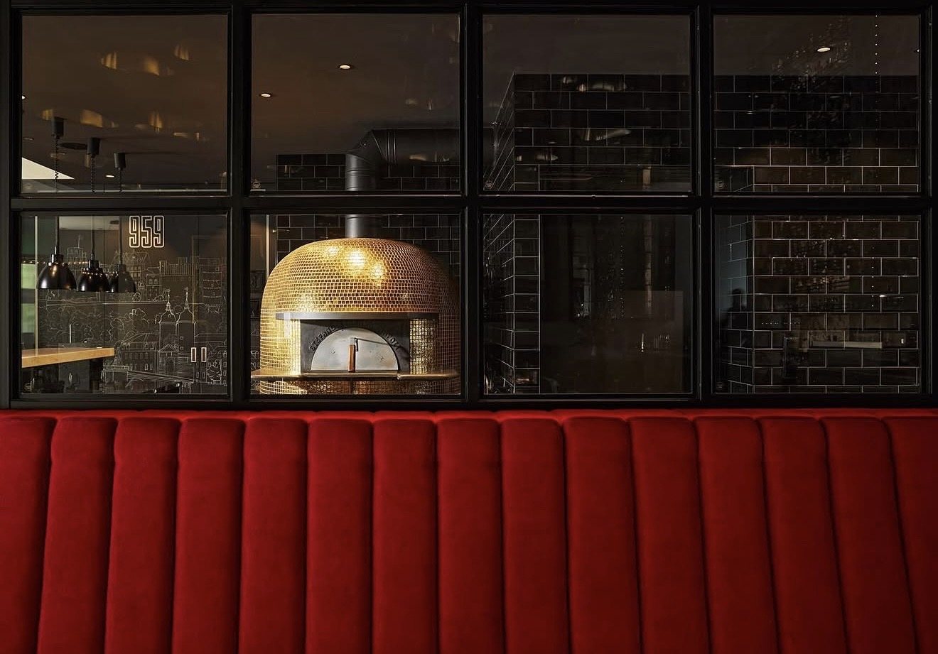 Pizzaofen hinter roter Sitzbank